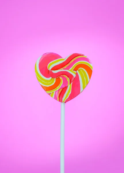 Corazón en forma de piruleta sobre un fondo rosa — Foto de Stock