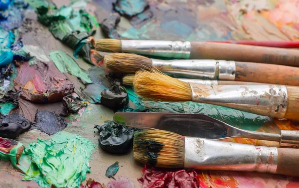 Usado pinceles en la paleta de un artista de pintura al óleo de colores para dr — Foto de Stock