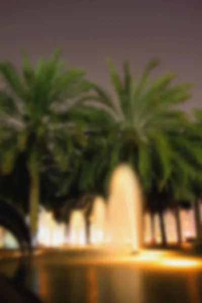Verschwommen Hintergrund Straßenfontänen, Palmen Abend lig — Stockfoto