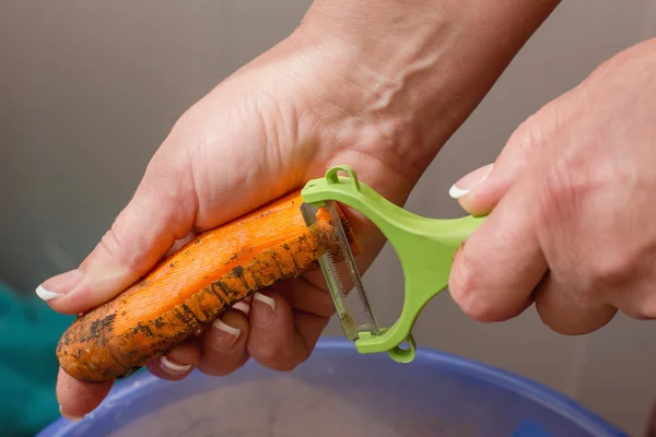 Närbild händer rena morötter, rengöring raw färska morötter, matlagning — Stockfoto
