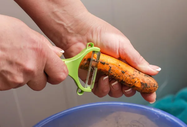 Närbild händer rena morötter, rengöring raw färska morötter, matlagning — Stockfoto