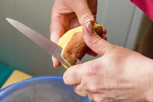 Närbild av händer som skalar potatis, rengöring rå färsk potatis — Stockfoto