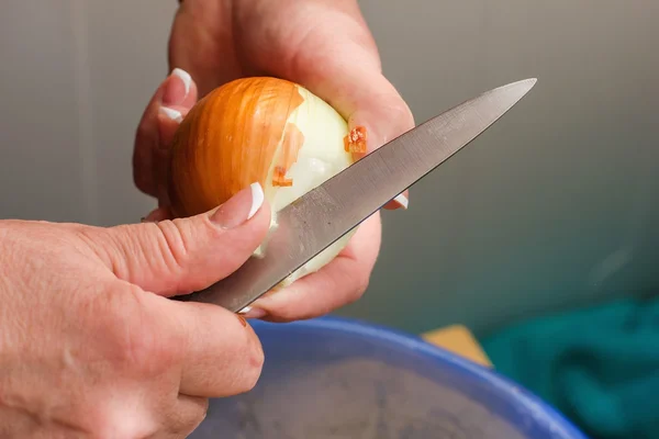 Närbild händer rena lök, rengöring rå färsk lök, matlagning i — Stockfoto