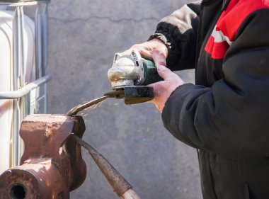 Keskinleştirme Bahçe değirmeni yakın çekim, taşlama / kaynak metal makine kullanarak çapa araçları ve yaymak, yumuşak odak kıvılcım
