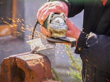 Keskinleştirme Bahçe değirmeni yakın çekim, taşlama / kaynak metal makine kullanarak çapa araçları ve yaymak, yumuşak odak kıvılcım
