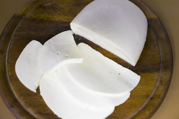 Queso fresco en rodajas en un Dostochka de madera enfoque muy suave — Foto de Stock