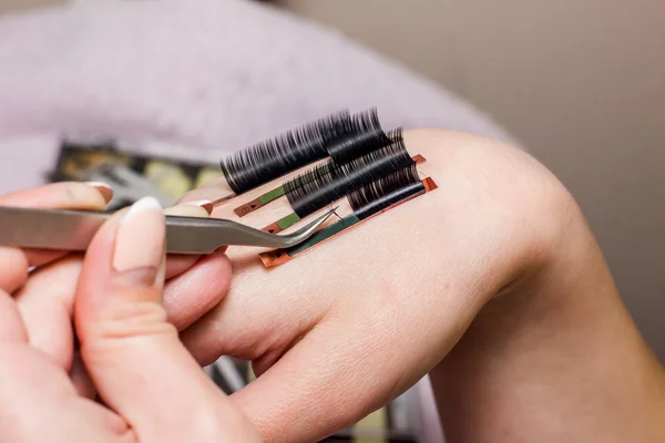 Extensiones de pestañas artificiales, la mano del maestro, la pestaña se extiende —  Fotos de Stock