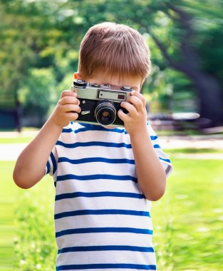Mutlu neşeli çocuk ile bir fotoğraf makinesi, açık havada fotoğraflandı bebek