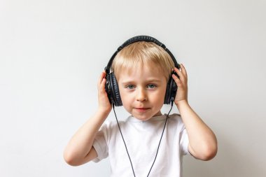 Beyaz bir müzik dinlerken kulaklık ile mutlu neşeli çocuk
