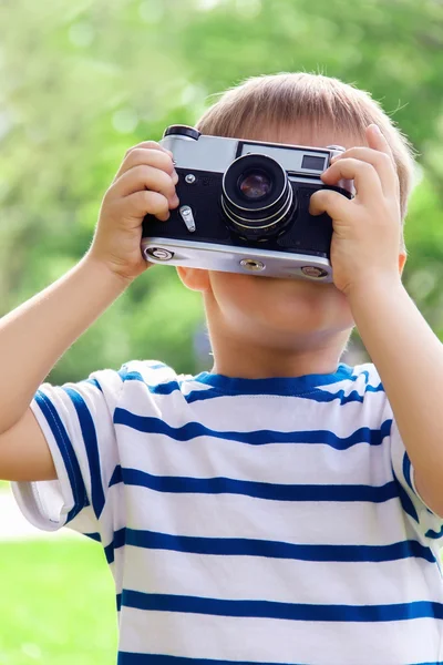 Szczęśliwy wesoły chłopiec z kamerą, baby sfotografowane na zewnątrz — Zdjęcie stockowe