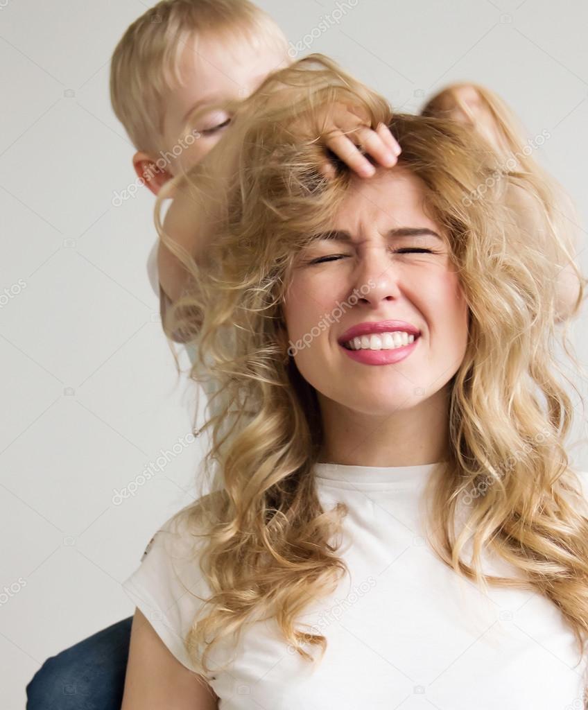 Mother With Long Curly Blond Hair Playing With His Son In A Stud