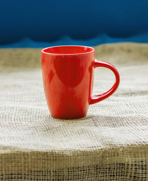 Copa roja en una mesa junto a la ventana en saco aislado, con una h —  Fotos de Stock