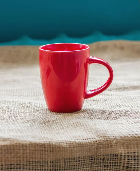 Copa roja en una mesa junto a la ventana en saco aislado, con una h —  Fotos de Stock