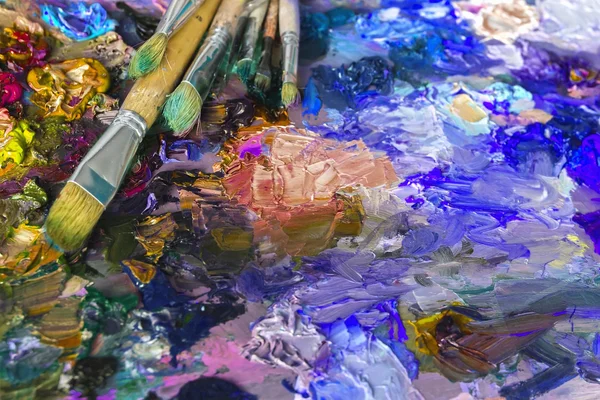 Paleta del artista con pinturas al óleo y pinceles utilizados para pintar un —  Fotos de Stock