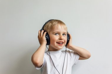 Beyaz b müzik dinlerken kulaklık ile mutlu neşeli çocuk