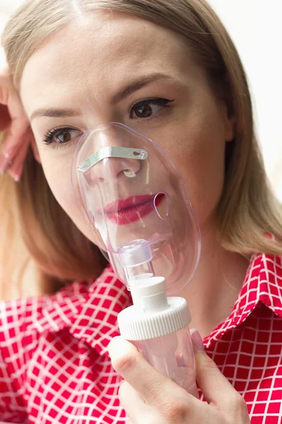 girl making inhalation, breathe through the inhaler treatment of