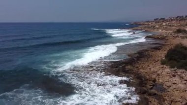 Paphos Kıbrıs adasındaki Akdeniz dalgalı kayalık plajın hava aracı videosu