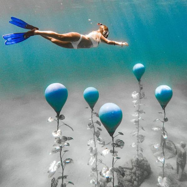 Photo sous-marine. Plongeuse libre en bikini blanc nageant près de statues bleues à Chypre — Photo