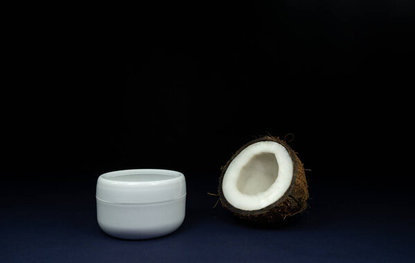 White jar of coconut batter or cream with coconut, cosmetic product on black background. Minimal concept. Showcase for presentation skincare products