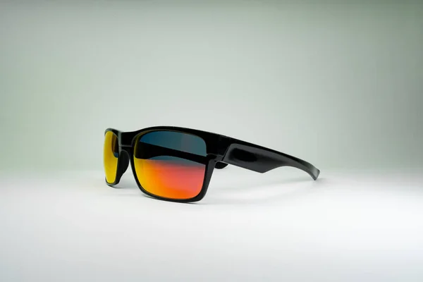 Fotografie produktu Sluneční brýle s oranžovým sklem a černým rámem na bílém pozadí. Šablona pro sociální média, web — Stock fotografie