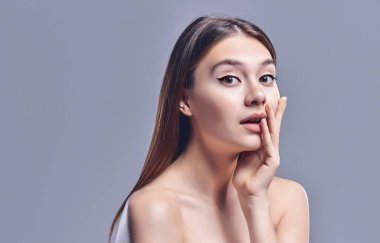 Kadın sürprizi el ele tutuşur. Temiz ve taze ciltli güzel bir kız. Yüz ifadeleri etkileyici. Kozmetik, güzellik ve kaplıca. Yüz bakımı tedavisi