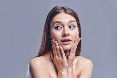 Kadın sürprizi el ele tutuşur. Temiz ve taze ciltli güzel bir kız. Yüz ifadeleri etkileyici. Kozmetik, güzellik ve kaplıca. Yüz bakımı tedavisi