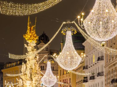 Avusturya, Viyana 'da Graben Caddesi' ndeki Veba Sütunu. Ünlü Kutsal Üçleme sütunu ve Avusturya 'nın başkentinin simgesi. Noel zamanı aydınlatılmış alışveriş caddesi.