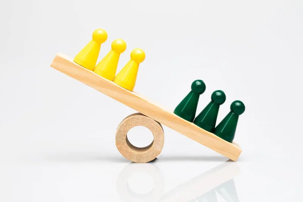 Grüne Und Gelbe Spielsteine Auf Einer Hölzernen Wippe Konzeptioneller Schlagabtausch — Stockfoto