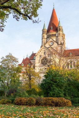 Avusturya, Viyana 'daki Assisi Kilisesi' nden Aziz Francis 'in nefes kesici sonbahar manzarası Tuna nehrinin kıyısına kurulmuş ve canlı düşen yapraklarla çevrili..