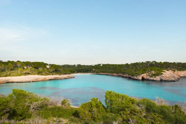 Cala Mondrago, Mallorca, İspanya 'nın güneydoğu kıyısında çarpıcı bir turkuaz körfez. Altın kumlu plajlar, kayalık kıyı şeridi ve Akdeniz çam ormanları temiz, mavi suları çevrelemektedir. Manzaralı bir doğal