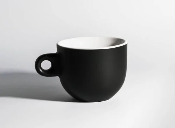 Fekete matt kávé csésze áll a fehér háttér — Stock Fotó