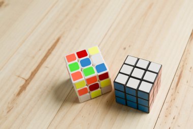 Çam ahşap arka plan üzerinde iki rubik küp.