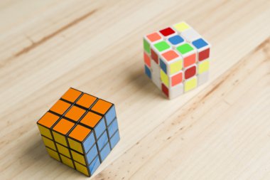 Çam ahşap arka plan üzerinde iki rubik küp.