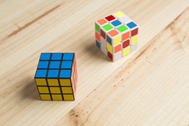 Çam ahşap arka plan üzerinde iki rubik küp.