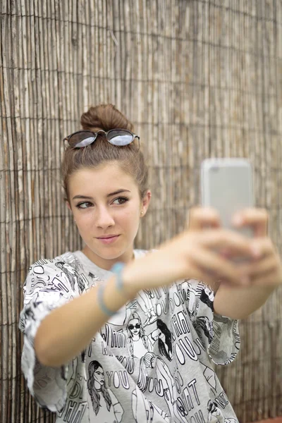 Chica joven con móvil en la mano — Foto de Stock