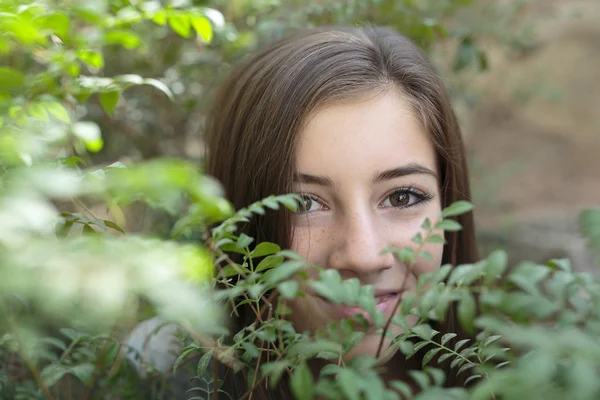 Face of a girl among branches of a tree — Stock Photo, Image