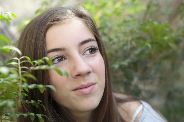 El rostro de una niña entre ramas de un árbol — Foto de Stock