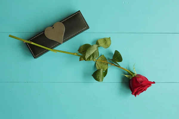 Rosa con un regalo per San Valentino su uno sfondo di legno dipinto di blu — Foto Stock