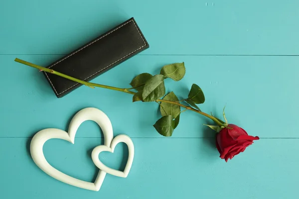 Rose avec un cadeau pour la Saint Valentin sur un fond de bois peint en bleu — Photo