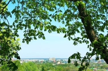 Ufuktaki güneşli yaz şehri mavi gökyüzünün altında.