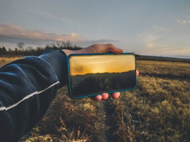 Cep telefonunda günbatımı yansıması