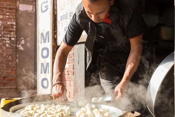 Mand forbereder dampet Momos, Nepal - Stock-foto