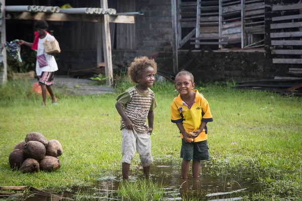 Duas crianças brincando em uma poça — Fotografia de Stock