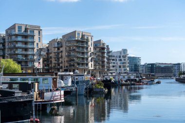 Kopenhag, Danimarka - 6 Ağustos 2024: Havneholmen bölgesindeki modern apartmanlar ve yüzen evler