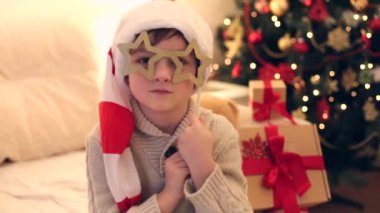 Noel ağacının etrafında oyuncak gözlüklü oynayan çocuk