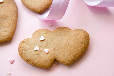 Üzerinde bir pembe kurdele ile Sevgililer günü için kalp şeklinde tatlı kurabiye.