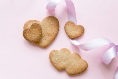 Üzerinde bir pembe kurdele ile Sevgililer günü için kalp şeklinde tatlı kurabiye.