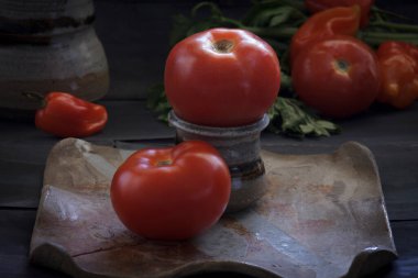 Ahşap bir masa üzerinde bir tabak içinde olgun domates