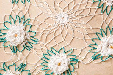 Çiçekler beyaz ve yeşil ahşap arka plan üzerinde dantel bardak altlığı peçete