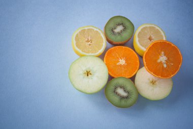 apple, orange cut into slices on a blue background